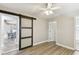 Bedroom featuring updated flooring, barn door to dining room, and a ceiling fan for added comfort at 6316 S Richard Ave, Tampa, FL 33616
