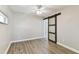 Bedroom featuring wood-look flooring and a sliding barn door to the ensuite at 6316 S Richard Ave, Tampa, FL 33616