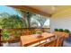 This staged porch features a wood table, chairs, and beautiful views of the surrounding trees at 6475 23Rd N St, St Petersburg, FL 33702