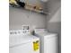 Functional laundry room equipped with a washer, dryer, and storage shelves at 6709 Lake Rochester Ln, Gibsonton, FL 33534