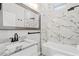 Modern bathroom featuring a marble-look shower and a sleek vanity with a framed mirror and white cabinets at 8038 27Th N Ave, St Petersburg, FL 33710