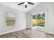 Bright bedroom featuring wood-look flooring, a ceiling fan, and sliding glass doors leading to the backyard at 8038 27Th N Ave, St Petersburg, FL 33710