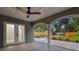 A covered patio with ceiling fan, French doors, an archway, and a view of the landscaped backyard at 8038 27Th N Ave, St Petersburg, FL 33710