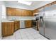 Functional kitchen featuring wood cabinets, stainless steel appliances, and a tile floor for ease of maintenance at 8335 Paddlewheel St, Tampa, FL 33637