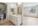 Bathroom vanity featuring ample counter space, a full-width mirror, and convenient access to the adjacent bedroom and toilet at 8419 Laurelon Pl, Temple Terrace, FL 33637