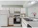 Kitchen features white appliances, plenty of counter space, and a stainless steel sink at 8419 Laurelon Pl, Temple Terrace, FL 33637