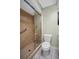 Bathroom with glass enclosed shower, white toilet, grab bar, and neutral paint at 908 Rosewood Ln, Palm Harbor, FL 34684