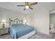 Bedroom with a comfortable queen bed, soft carpet, a ceiling fan, and ensuite bathroom access at 908 Rosewood Ln, Palm Harbor, FL 34684