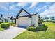 Beautiful home showcasing an attached garage, lush lawn, and manicured shrubbery at 908 Rosewood Ln, Palm Harbor, FL 34684
