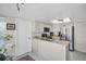 Galley kitchen featuring white cabinetry, stainless steel appliances, and tile flooring at 908 Rosewood Ln, Palm Harbor, FL 34684