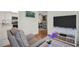 Living room with a view into kitchen. Features a modern TV, chair and decor at 908 Rosewood Ln, Palm Harbor, FL 34684