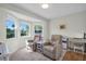Bright living room with two leather chairs in front of bay windows; side table, desk and carpeted floor at 908 Rosewood Ln, Palm Harbor, FL 34684