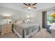 Well-lit main bedroom featuring neutral colors, a ceiling fan, and bedside tables at 908 Rosewood Ln, Palm Harbor, FL 34684