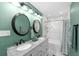 Renovated bathroom featuring double sinks with granite counters, modern lighting fixtures and a marble tiled shower and floors at 910 Edgedale Cir, Brandon, FL 33510