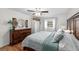 Cozy bedroom featuring a large bed, wooden dresser, ceiling fan, and natural light from the window at 910 Edgedale Cir, Brandon, FL 33510