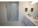 Bathroom features glass shower, dual sink vanity with quartz countertops, and marble floors at 9445 Eldridge Rd, Spring Hill, FL 34608
