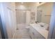 A stylish bathroom with marble-look tile, white cabinets, and a shower-tub combination at 9445 Eldridge Rd, Spring Hill, FL 34608