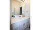 Bright bathroom features a large mirror, white cabinets, and elegant fixtures at 9445 Eldridge Rd, Spring Hill, FL 34608