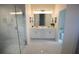 Bright bathroom with double sink vanity, frameless glass shower, and marble tile flooring at 9445 Eldridge Rd, Spring Hill, FL 34608
