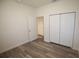 A bedroom with wood-look flooring, white walls, and a double-door closet at 9445 Eldridge Rd, Spring Hill, FL 34608