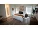 Stylishly decorated bedroom with wood-look floors, two windows, and decorative wall hangings at 9445 Eldridge Rd, Spring Hill, FL 34608