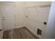 Bright laundry room with wood-look flooring and white wire shelving for organized storage at 9445 Eldridge Rd, Spring Hill, FL 34608