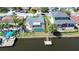 Aerial view of a waterfront home featuring a screened pool, private dock, and lush tropical landscaping at 9826 Island Harbor Dr, Port Richey, FL 34668