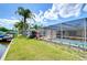 Canal-front home with screened-in pool, dock, and lush landscaping, offering a private outdoor retreat at 9826 Island Harbor Dr, Port Richey, FL 34668