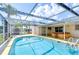 Backyard showcasing the pool, spa, screened-in lanai, and canal view at 9826 Island Harbor Dr, Port Richey, FL 34668