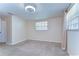 Neutral bedroom featuring tan carpet, a ceiling fan, and a bright window at 9826 Island Harbor Dr, Port Richey, FL 34668
