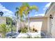 Wrought iron gate leading to a cozy home with lush, tropical landscaping at 9826 Island Harbor Dr, Port Richey, FL 34668