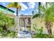 Charming brick gate leading to a lovely home with lush tropical landscaping at 9826 Island Harbor Dr, Port Richey, FL 34668