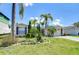 Charming single Gathering home featuring a well-manicured lawn and lush tropical landscaping at 9826 Island Harbor Dr, Port Richey, FL 34668