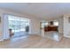 Open living space with wood floors, sliding glass doors to a pool, and adjacent kitchen area at 9826 Island Harbor Dr, Port Richey, FL 34668