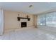 Bright living room with a brick fireplace, tiled floor, and large windows with blinds at 9826 Island Harbor Dr, Port Richey, FL 34668
