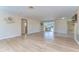 Large living room with wood laminate floors and sliding door to the pool at 9826 Island Harbor Dr, Port Richey, FL 34668