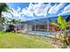 Screened-in pool with tropical landscaping, offering a private outdoor oasis for enjoying the Florida sunshine at 9826 Island Harbor Dr, Port Richey, FL 34668