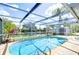 Screened-in pool area with a view of the backyard, canal, and surrounding landscape at 9826 Island Harbor Dr, Port Richey, FL 34668