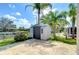 Outdoor shed in the backyard, surrounded by lush landscaping and canal view at 9826 Island Harbor Dr, Port Richey, FL 34668