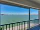 Expansive waterfront view from a screened-in balcony with black metal railing at 7910 Sun Island S Dr # 301, South Pasadena, FL 33707