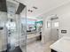 Bathroom featuring a luxurious shower, bathtub, a large mirror, and contemporary fixtures and neutral decor at 115 16Th St, Belleair Beach, FL 33786