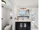 Well-lit bathroom with modern vanity, mirror, and arched doorway leading to the bath and shower area at 115 16Th St, Belleair Beach, FL 33786