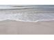 Close-up view of the shoreline with gentle waves washing onto the beach at 115 16Th St, Belleair Beach, FL 33786