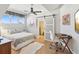 Bright bedroom with a ceiling fan, sliding barn door to closet, and an adjacent workstation at 115 16Th St, Belleair Beach, FL 33786