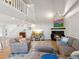 Bright living room boasts high ceilings, a cozy fireplace, and stylish furnishings with a split staircase above at 115 16Th St, Belleair Beach, FL 33786