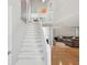 Bright staircase with hardwood floors leading to a cozy living room with a plush sofa at 115 16Th St, Belleair Beach, FL 33786
