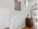 Bright staircase with hardwood floors, white railing, and colorful artwork on the wall at 115 16Th St, Belleair Beach, FL 33786