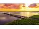 Aerial view of a pier extending into the calm water during sunset, providing a scenic walking and viewing area at 116 Shore Drive Pl, Oldsmar, FL 34677