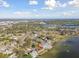 Expansive aerial view showcasing a waterfront property with dock access, set in a vibrant, green community near the bay at 116 Shore Drive Pl, Oldsmar, FL 34677