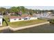A waterfront home with a lush green lawn, seawall, and partial view of the water at 116 Shore Drive Pl, Oldsmar, FL 34677